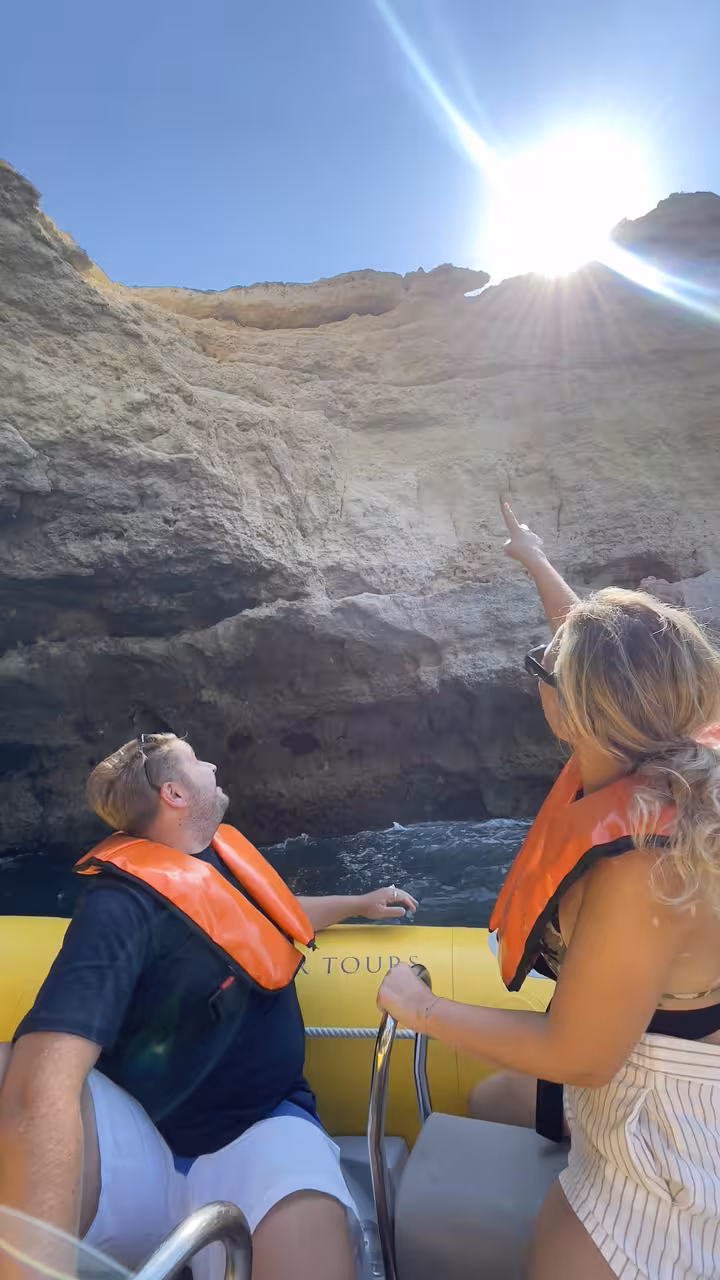 Guests in life jackets on a private boat tour admiring Algarve cliffs en route to Benagil Cave