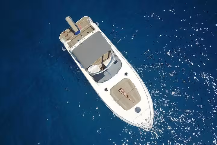 Luxurious private boat cruising through clear Capri waters under a sunny sky, ideal for exclusive tours.