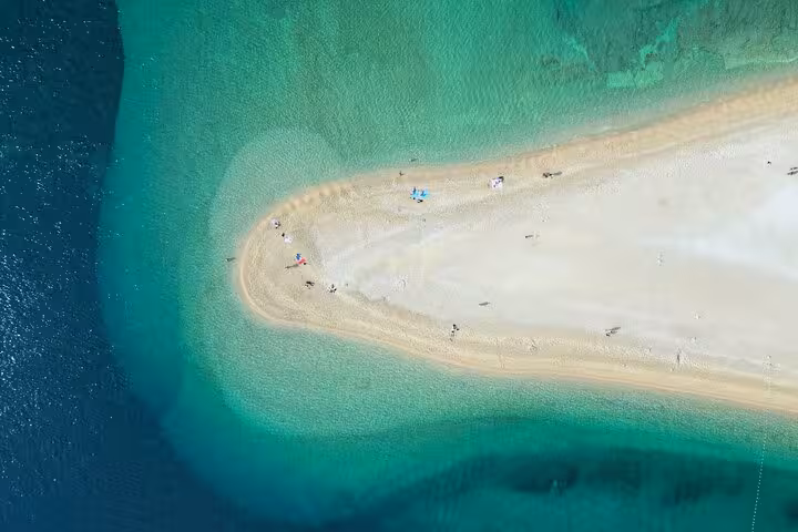 Drone view of a sandy spit and emerald shallows, a scenic stop on a private Croatia boat tour