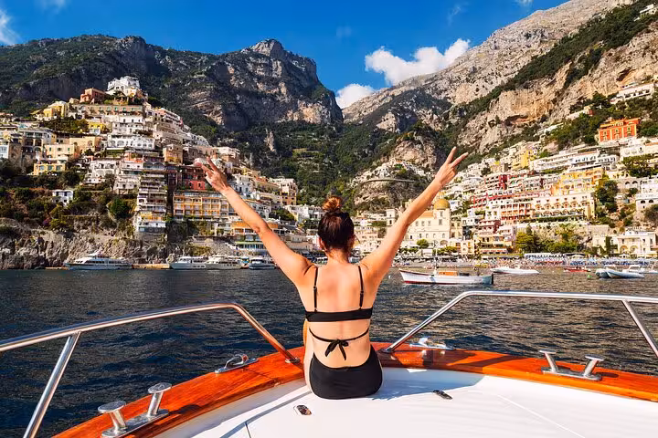 Traveler enjoying the breathtaking view of Positano from the deck of a Gozzo 750 boat on a private tour.