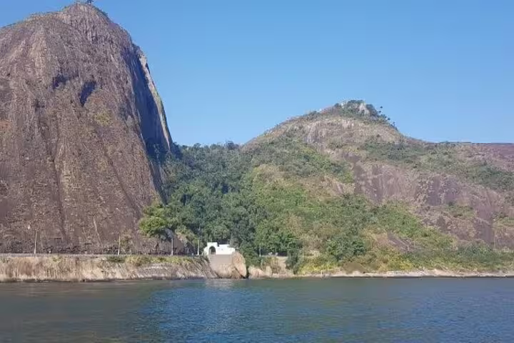 Scenic view of rocky hills and lush greenery along the Rio coastline from a private boat tour adventure.