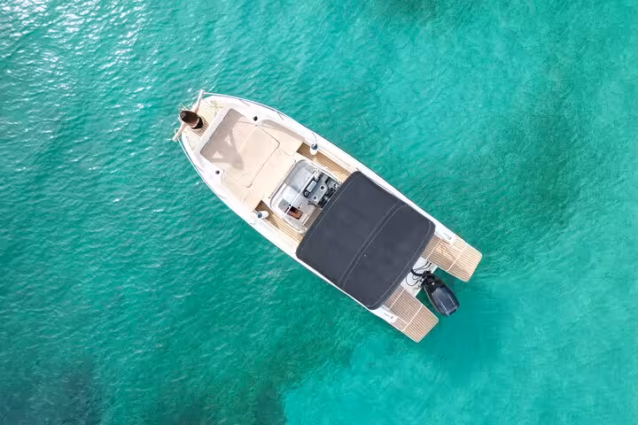 Top view of a sleek private boat floating in crystal-clear waters during a San Antonio tour.
