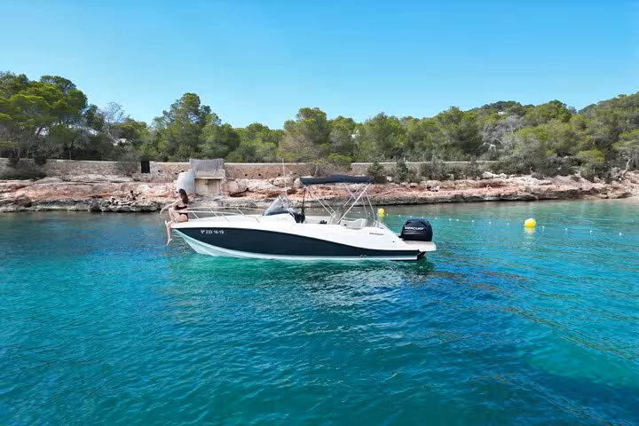 Idyllic scene of a private boat anchored in turquoise waters of San Antonio, ideal for snorkeling and paddle surfing.