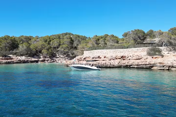 Overhead shot of a private tour boat in San Antonio's crystal-clear water, perfect for snorkeling and paddle surfing.