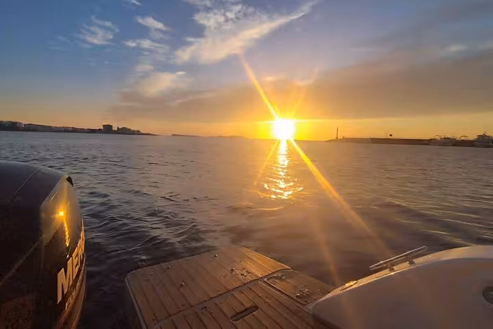 Serene sunset view from a private boat tour in San Antonio with golden reflections on the calm water.
