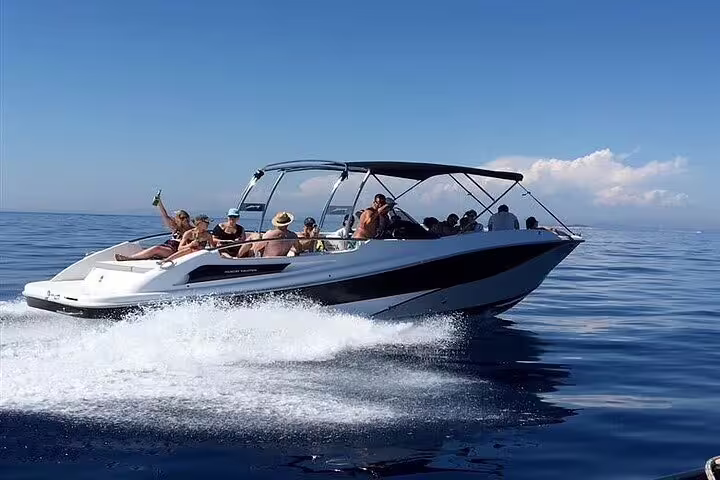 Group enjoying a lively private boat tour in Santos under clear blue skies, perfect for a day with barbecue and drinks.