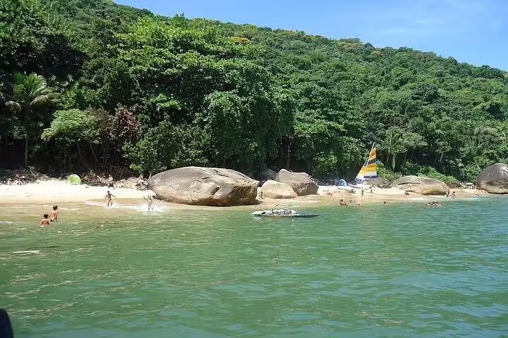 Scenic view of a secluded beach with lush greenery on a private boat tour in Santos.