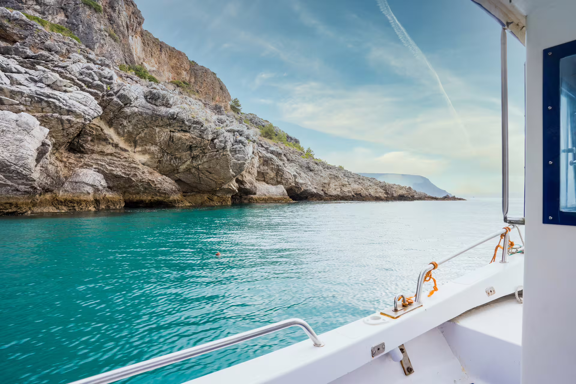 Private boat tour along the stunning rocky coastline and turquoise waters of Sesimbra in Arrábida Park, Portugal.