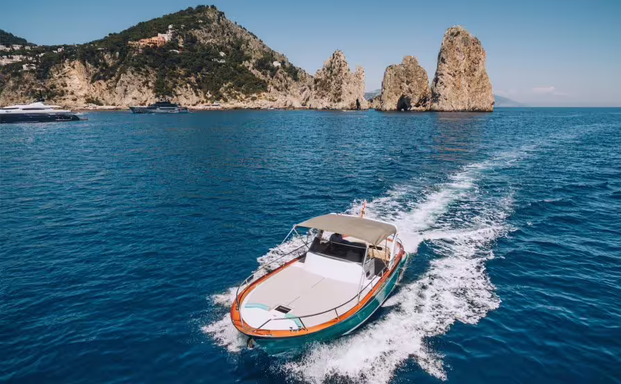 Speeding private boat transfer between Sorrento and Capri, passing Faraglioni rocks on the sparkling Tyrrhenian Sea