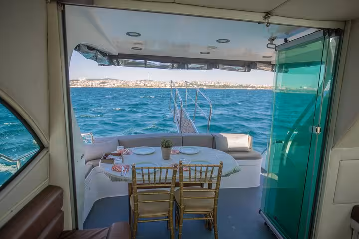 Private Bosphorus yacht cruise Istanbul with onboard dining setup, sea views and cozy lounge seating