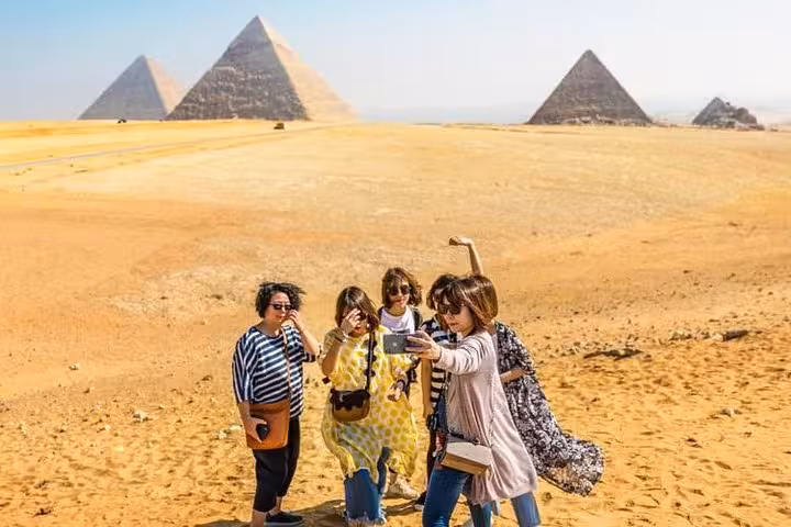 Tourists taking photos with Giza Pyramids on private Cairo day trip from Hurghada, Makadi Bay, Soma Bay, El Gouna