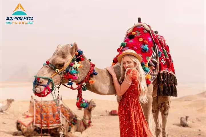 Traveler with decorated camel in Sahara-style dunes, private 2-hour camel ride near Giza Pyramids