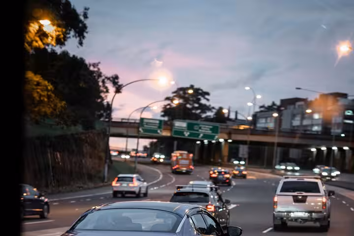 Multi-lane highway at dusk with cars and overpass on private transfer route between Colmar and Strasbourg