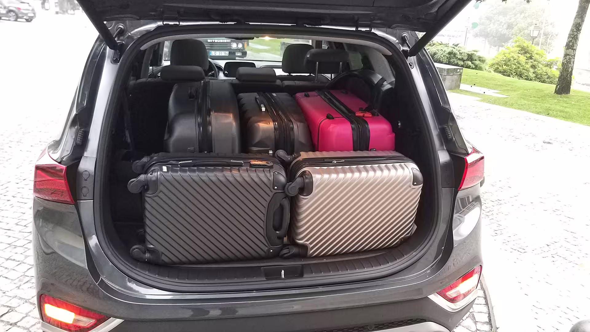 Car trunk packed with suitcases for efficient luggage transport from Porto to Povoa de Varzim.