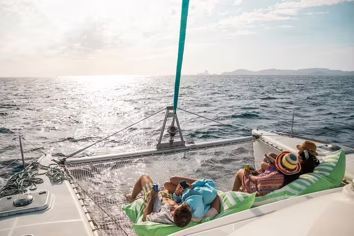 Relaxing on a private catamaran in the sun-drenched waters between Ibiza and Formentera during a full-day luxury trip.