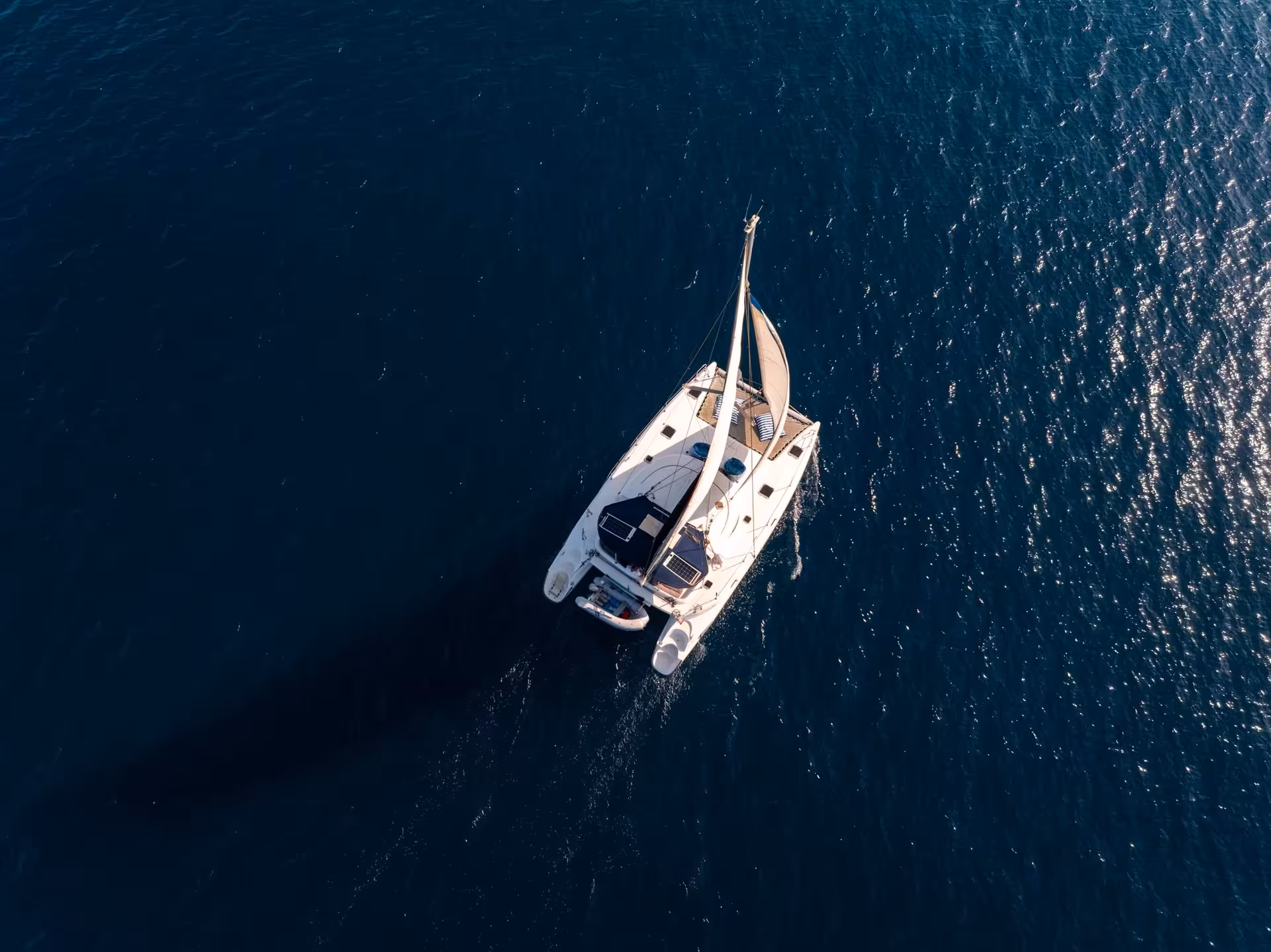 Aerial view of a white catamaran sailing on deep blue waters near Cannes
