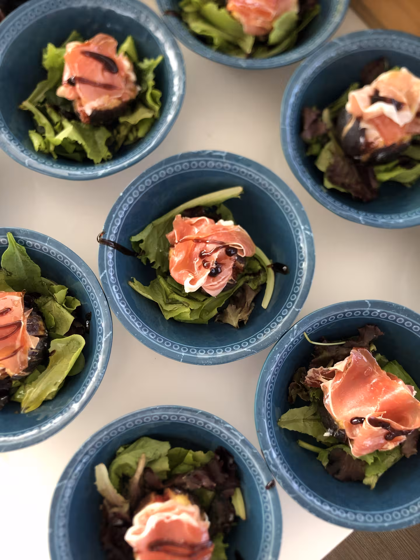 Chef-prepared appetizer bowls with mixed greens and prosciutto, plated for a private chef dining experience