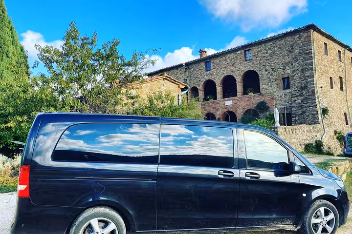 Luxurious black van ready for a private day trip from Civitavecchia Port to Rome with historic villa in the background.