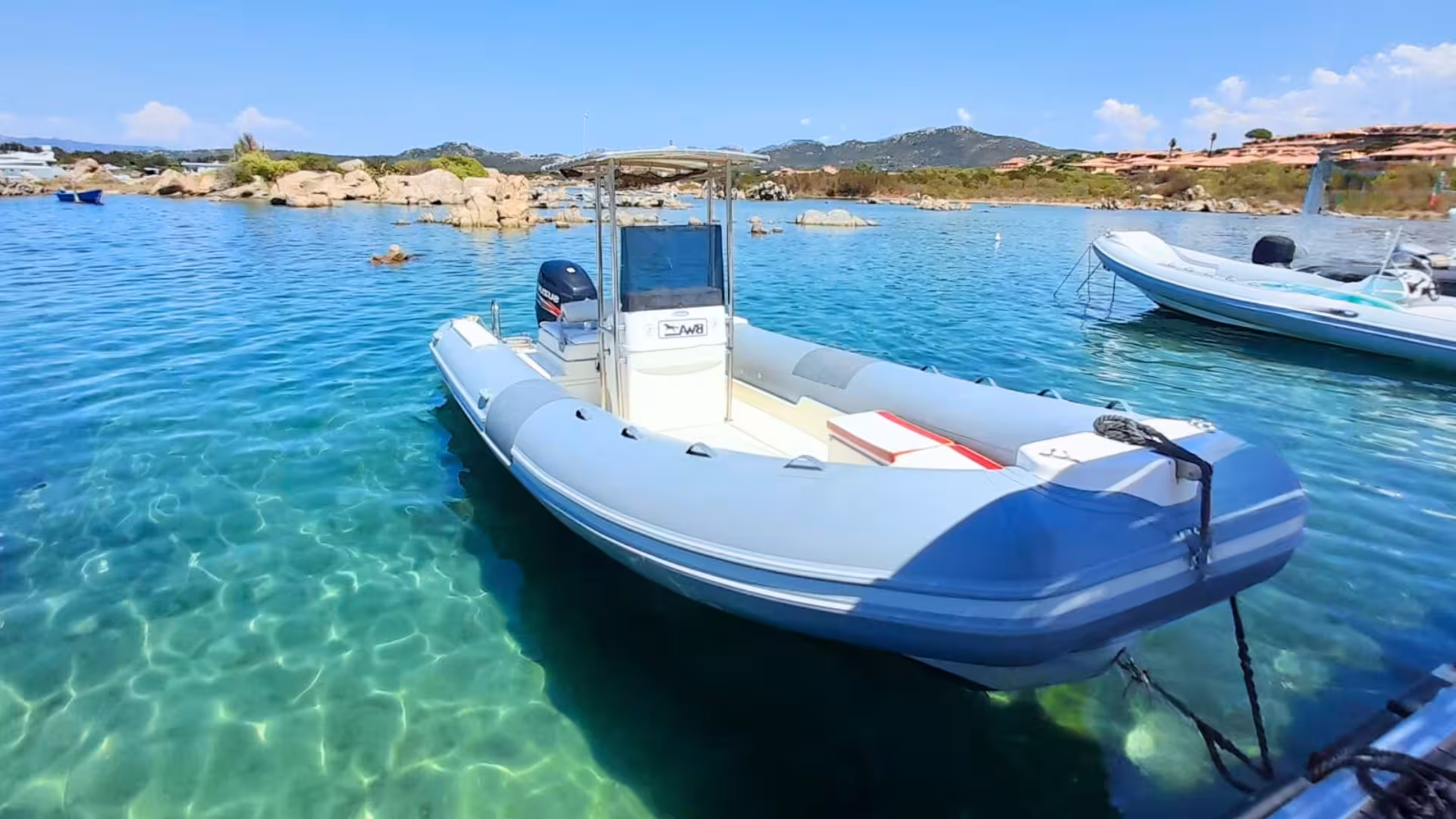 Close-up of a private dinghy in clear blue water, ready for a tour between Tavolara and La Maddalena Archipelago.