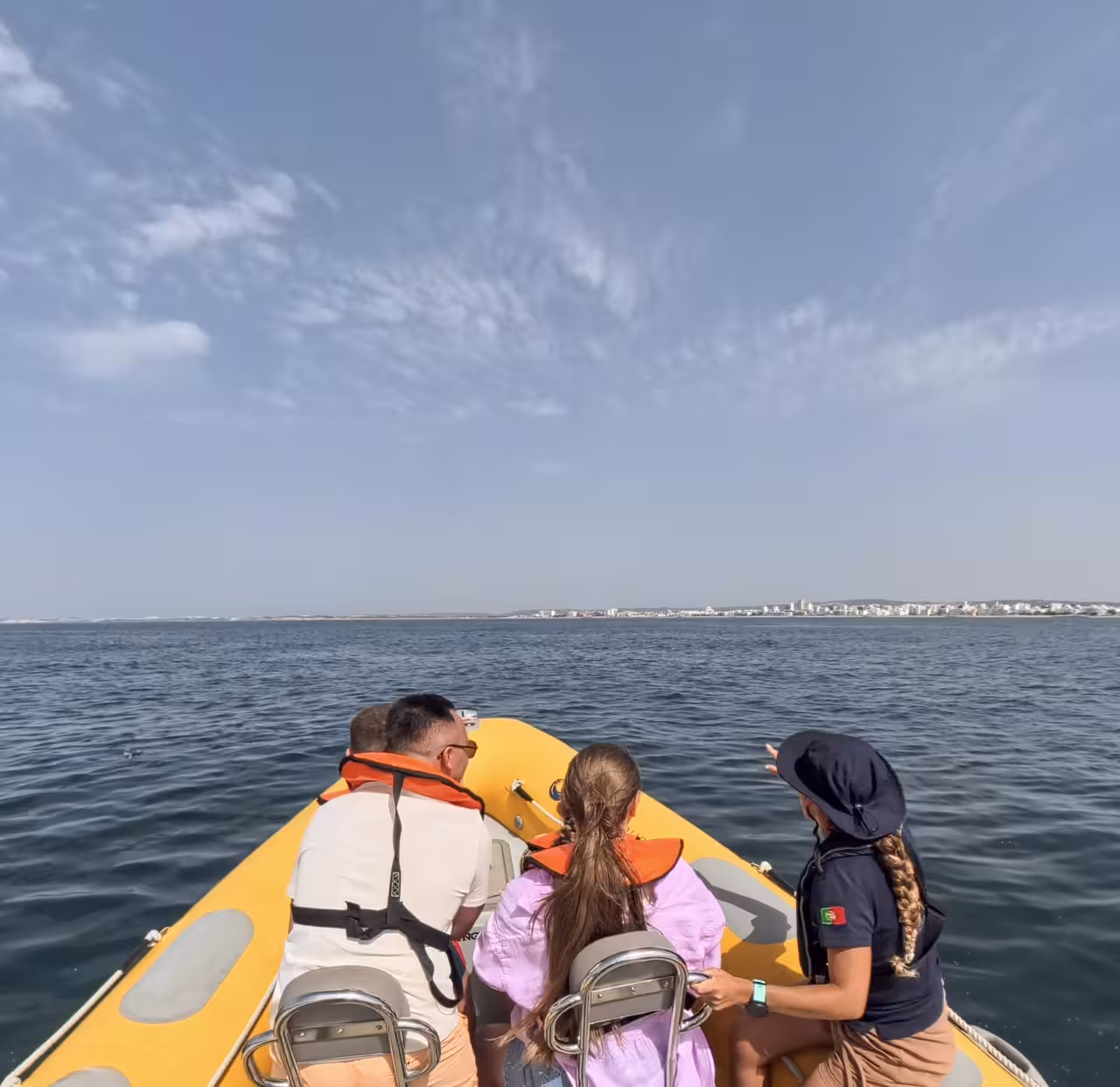Family on a private dolphin watching boat tour from Vilamoura Marina cruising the Algarve coast near Vilamoura