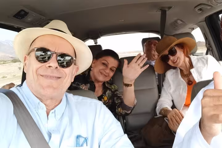 Happy friends in air-conditioned vehicle en route to Nizwa on a private evening tour, ready to explore Oman’s heritage city