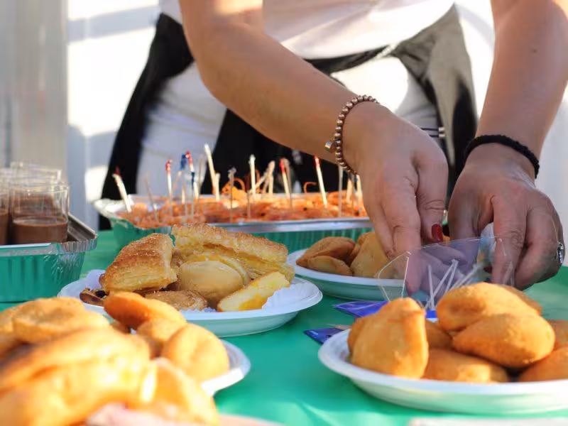 Catered finger foods and desserts are arranged on a buffet table for a private boat event, perfect for groups and celebrations