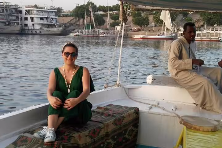 Traveler relaxing on a private felucca boat on the Nile in Cairo with local captain, calm river cruise