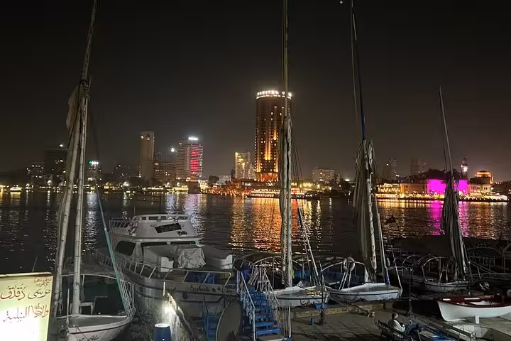 Nighttime private felucca dock on the Nile River in Cairo with illuminated skyline and riverside lights