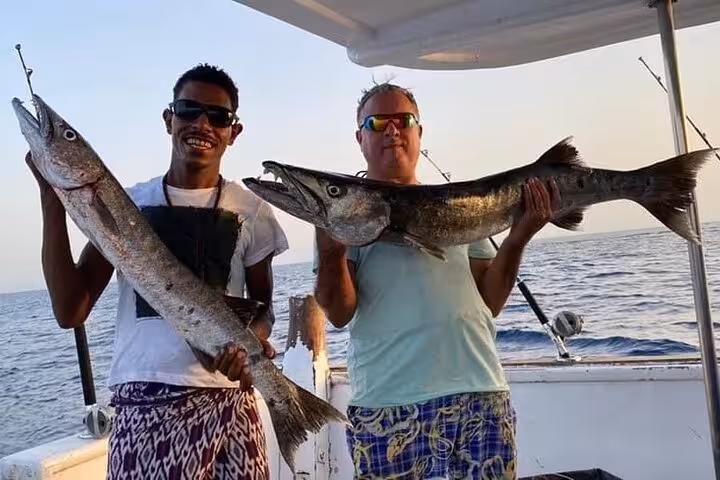Guests holding freshly caught barracuda on a private 3-hour fishing tour boat in Hurghada Safaga Red Sea