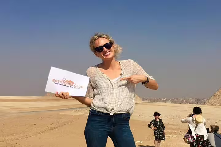Happy traveler posing on private Giza Pyramids tour in Cairo desert, photo stop near pyramids viewpoint