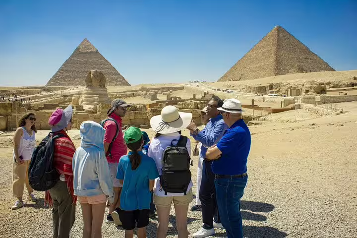 Tour group with local guide at Giza Plateau, pyramids view on private three-day guided Cairo and Alexandria trip