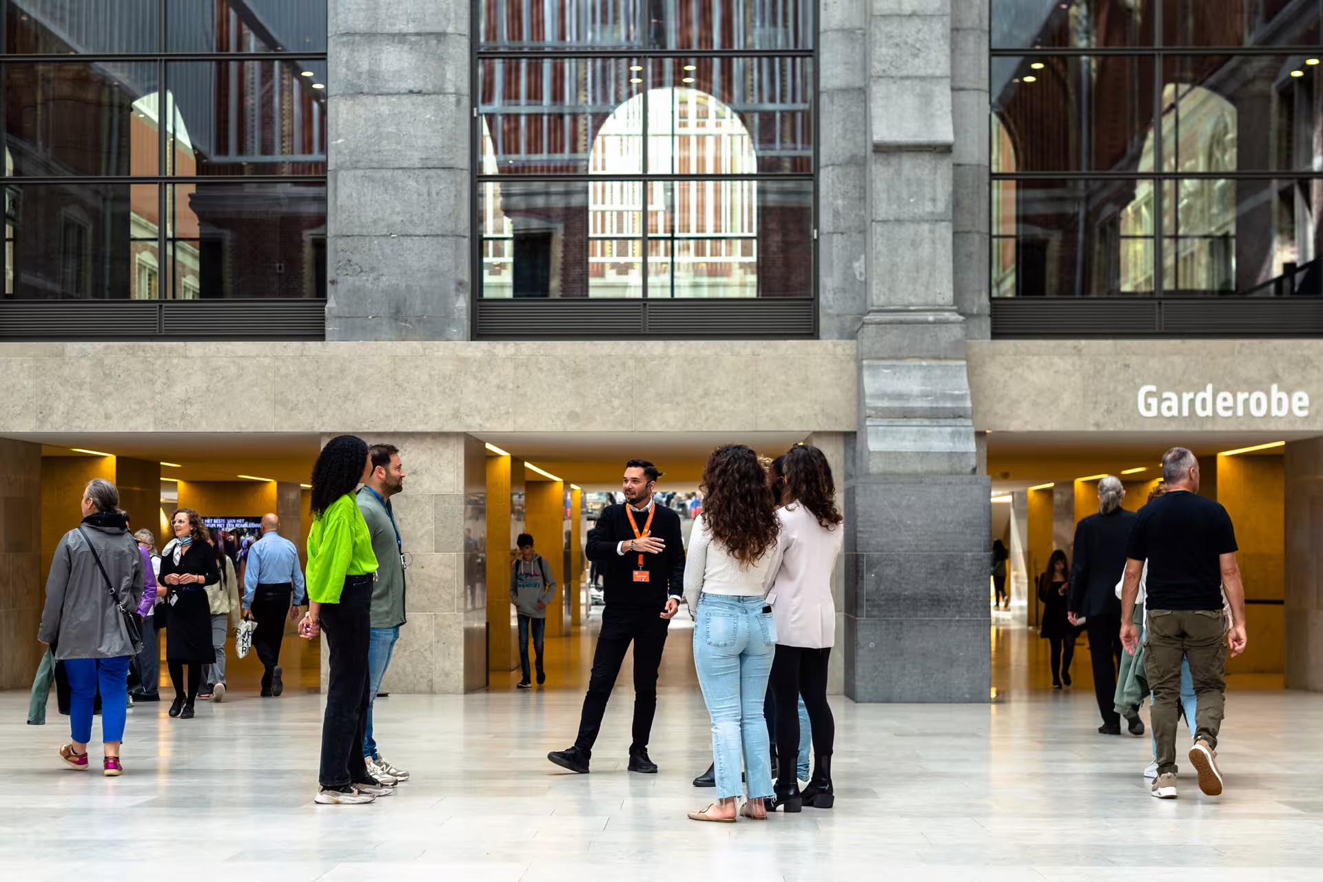 Visitors gather for a private guided tour at the Rijksmuseum, exploring art and history in Amsterdam's iconic museum.