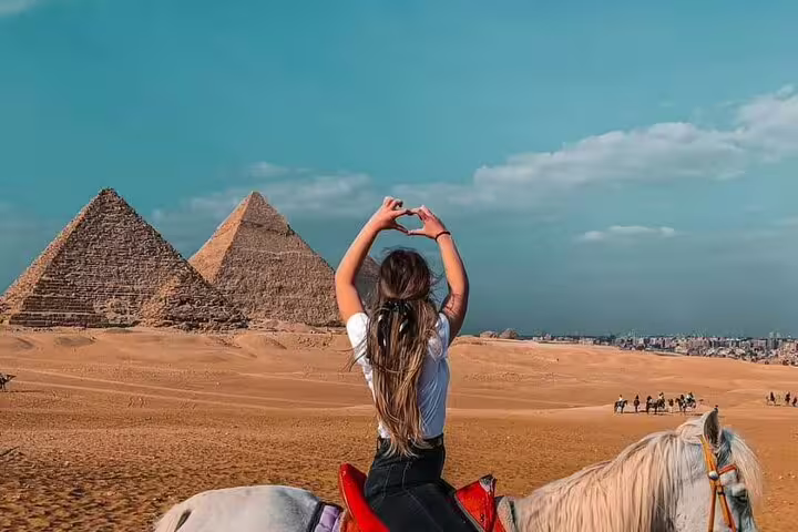 Traveler on horseback facing the Giza pyramids in Egypt, perfect for a private 2-hour horse ride desert tour