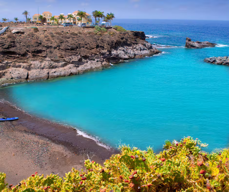 Turquoise waters and rugged cliffs at a secluded beach, perfect for a private island excursion adventure.