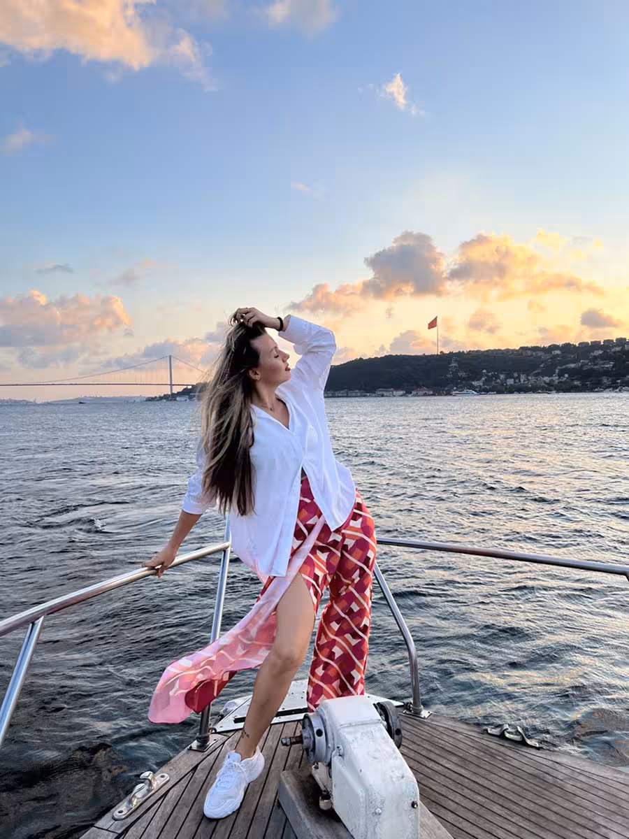 Woman posing on a private Istanbul yacht at sunset on the Bosphorus, scenic cruise and swimming tour experience