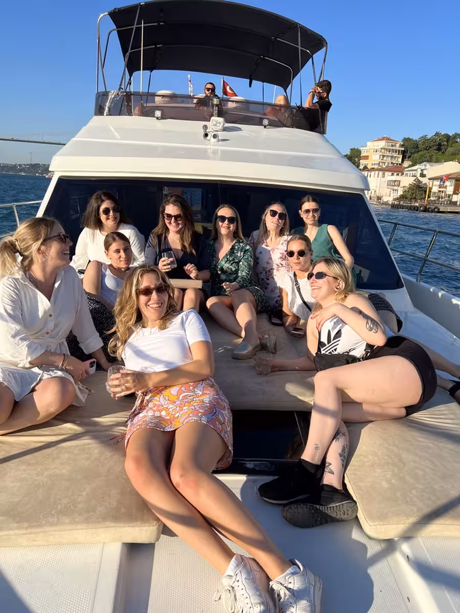 Group relaxing on the bow during a private Istanbul yacht swimming tour, cruising the Bosphorus in sunny weather