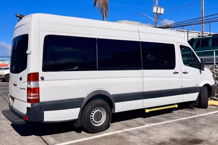 Exterior view of a white private KOA airport transfer van ready for convenient and reliable island transportation.