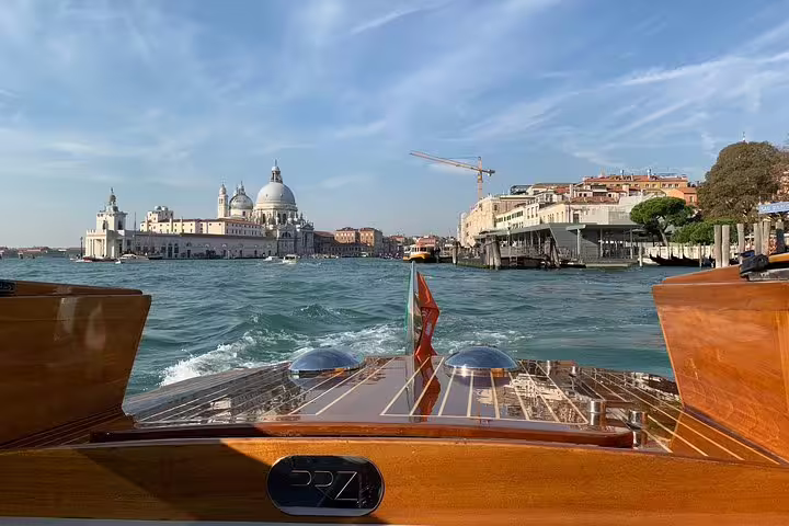 Luxurious LimoBoat cruising past Venice's iconic architecture on a Private Murano, Burano, and Torcello tour.