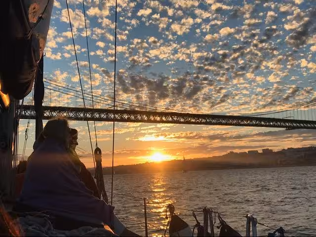 Private Lisbon sunset tour by sailboat on the Tagus River with 25 de Abril Bridge views at dusk