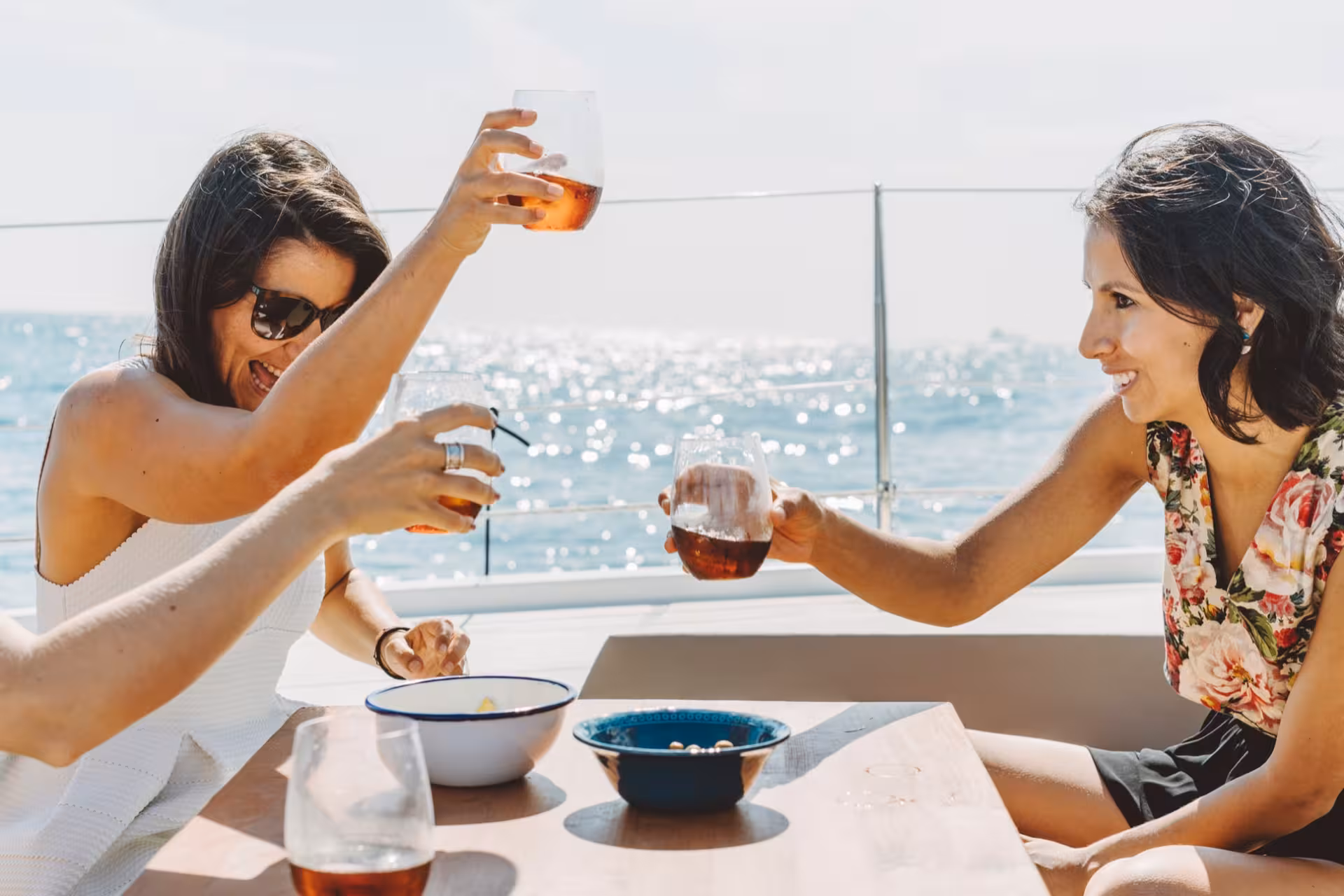 Friends toasting drinks on a private luxury Bali 4.1 catamaran cruise in Barcelona, Mediterranean views