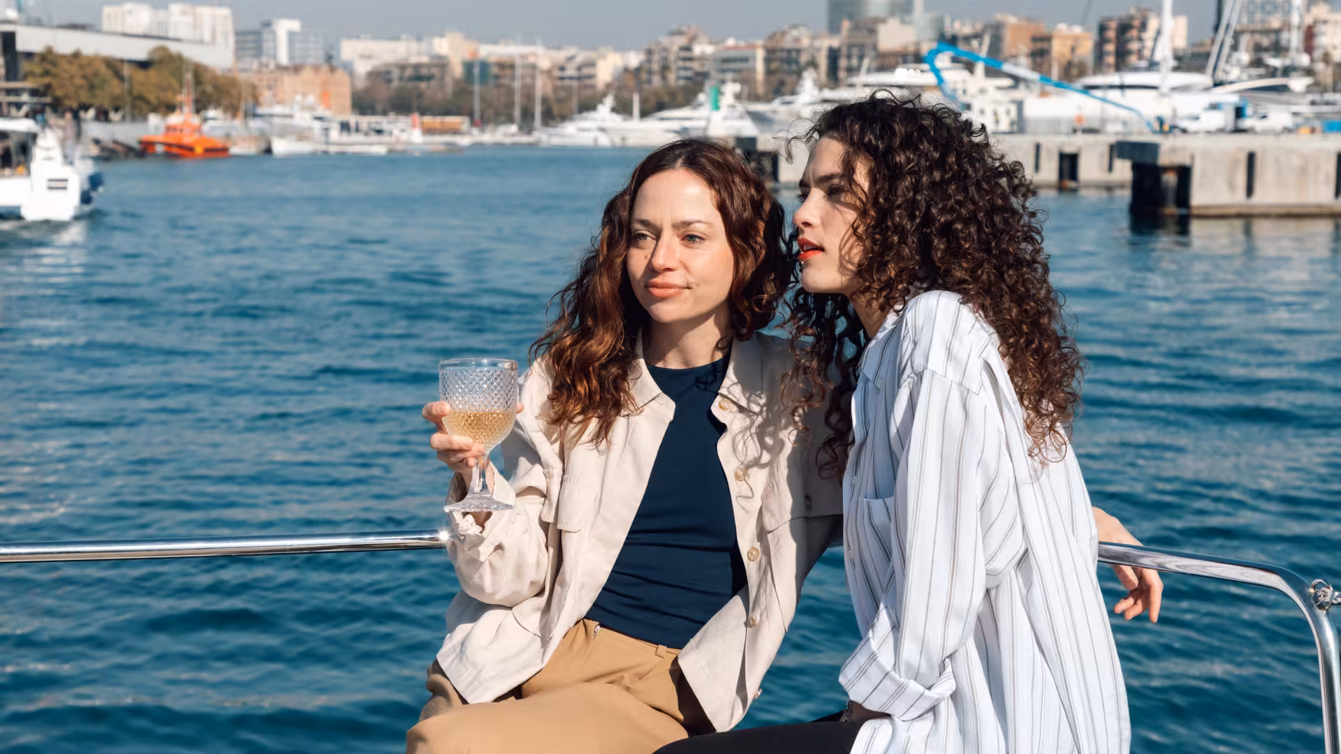 Guests sipping cava on a private luxury catamaran in Barcelona marina, Bali 4.2, 4-hour sailing charter