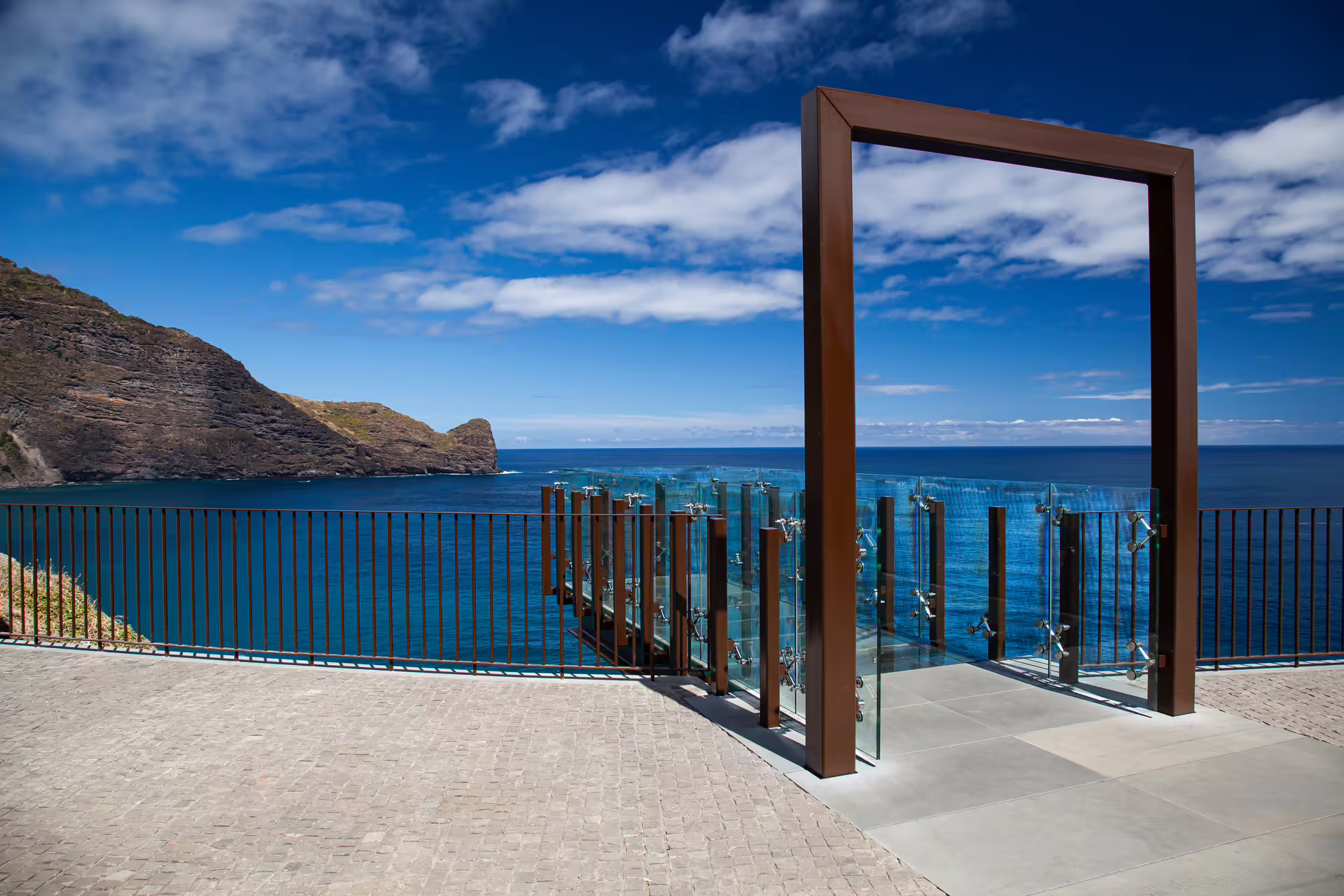 Modern viewpoint with glass railing overlooking the stunning coastline of Madeira, perfect for a private, customizable tour.