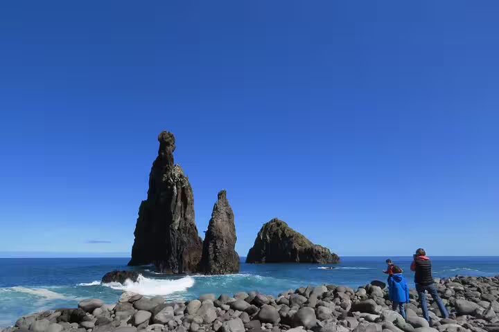 Tourists enjoy stunning rock formations and blue ocean views on the Private Magical Shore Excursion West.