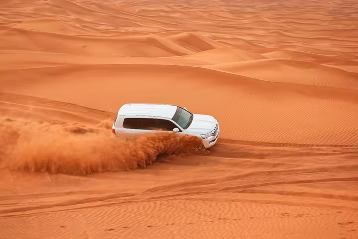 4x4 dune bashing across red sand dunes on a private morning desert safari, thrilling off-road ride in the UAE