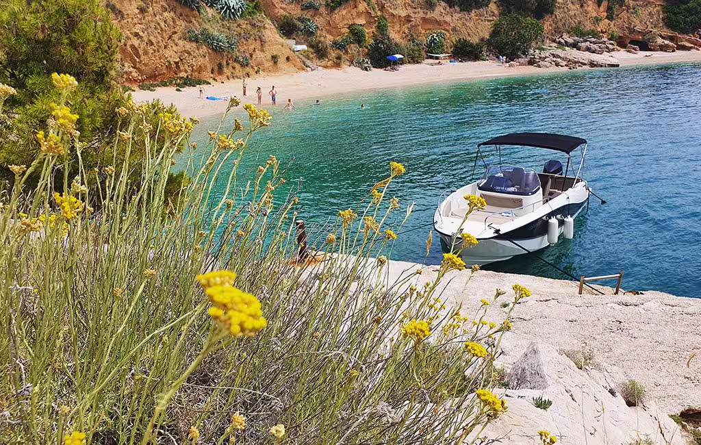 Private motorboat moored by a quiet cove beach near Brac and Solta on a Split private boat tour
