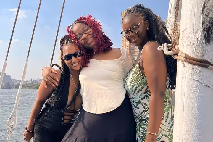Friends celebrating a birthday on a private Nile boat in Cairo, enjoying lunch or dinner cruise with skyline views