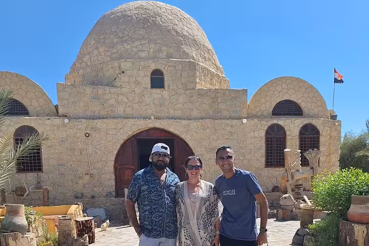 Tourists enjoy a cultural experience at a historic site in the Egyptian desert on a private overnight camping tour.