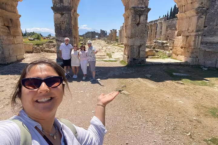 Private Pamukkale tour from Kusadasi or Selcuk with guide and guests at Hierapolis ruins and Roman archway