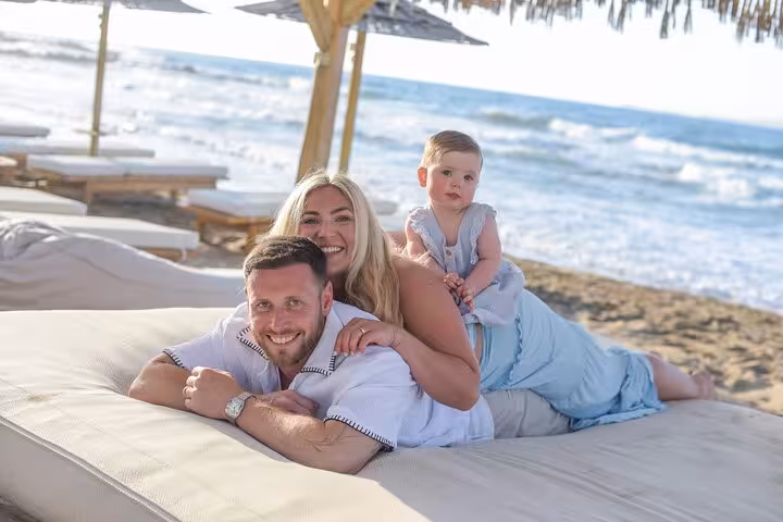 Happy family enjoying a private photoshoot on Analipsi beach with scenic ocean views and relaxing atmosphere.