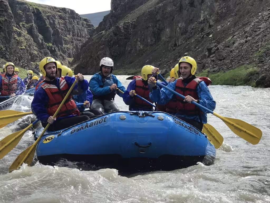 Adventurous group enjoying private rafting on West Glacial River with stunning canyon views, starting from Akureyri.